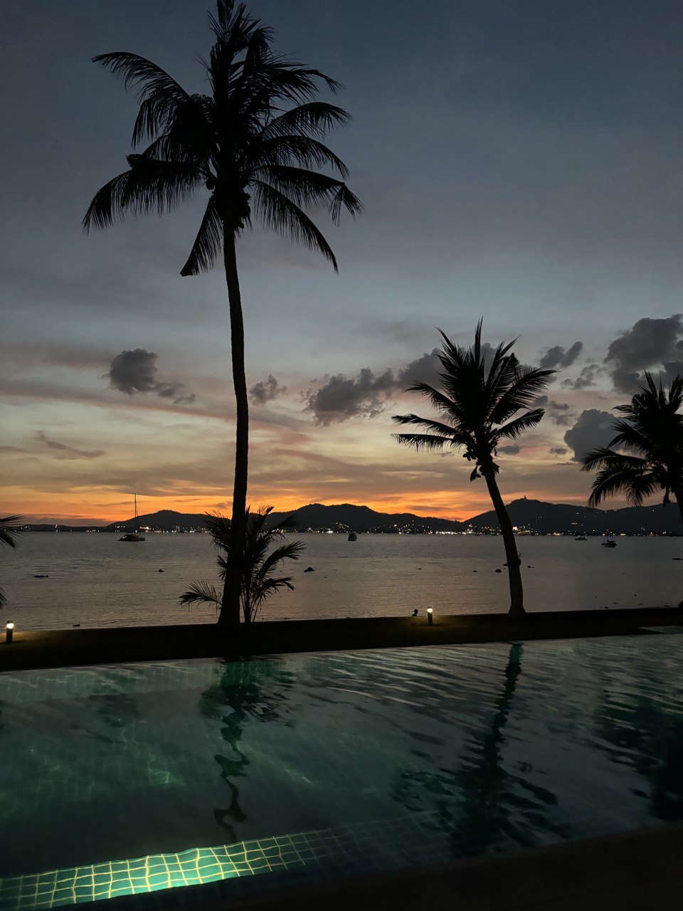 Zachód słońca przy basenie z palmami